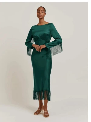 Grön långklänning med fransar - Snygg grön långklänning med långa ärmar och fransdetaljer längs ärmslut och nederkant. Klänningen har en markerad midja och är tillverkad i ett mjukt, slätt material som ger ett elegant fall. Perfekt för dig som vill sticka ut med coola detaljer.