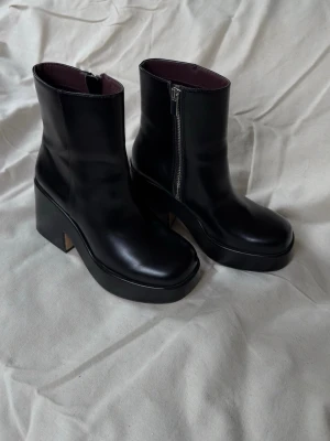 Svarta platåstövletter med dragkedja och chunky klack  - Snygga svarta stövletter med chunky platåklack och dragkedja på sidan. Använda 1 gång. 