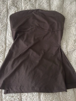 Brun tubtop i stretchigt tyg - Säljer en brun tubtop i mjukt och stretchigt material. Storlek xs men passar S,m. saknar lapp🧸🧸 