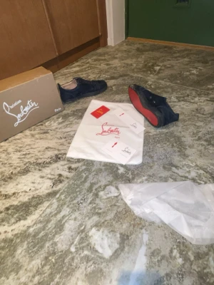 Christian Louboutin svarta sneakers - Säljer ett par svarta sneakers från Christian Louboutin med ikoniska röda sulor. Skorna har en låg profil och är tillverkade i ett lyxigt material som ger en exklusiv känsla. Perfekt för dig som vill sticka ut med stil och kvalitet.