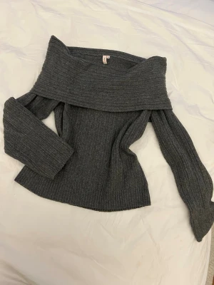 Grå off shoulder stickad tröja - Trendig grå stickad tröja med off shoulder-design och långa ärmar från Nelly. Tröjan är oversized så passar även S/M💕