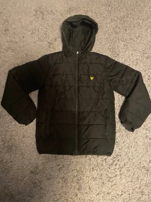 Svart Lyle & Scott jacka med huva - Storlek:12-13 år, inköpt från kids brand store och är i bra skick. 