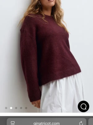 Vinröd stickad tröja Gina Tricot - Mysig vinröd stickad tröja från Gina Tricot med rund halsringning och långa ärmar. Tröjan har en relaxed passform och ribbade muddar vid ärmslut och nederkant. Perfekt för lager på lager under kyliga dagar.