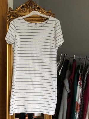 Vår/Sommarklänning - Superfin och skön vit/svartrandig klänning ifrån VILA.  Storlek: L. Längd: 85cm. Armhåla till armhåla 50cm. 55kr