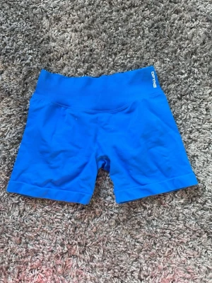 Blå seamless shorts från DFYNE - Blå seamless träningsshorts från DFYNE med hög midja och korta ben. Tillverkade i ett stretchigt och mjukt material som sitter skönt vid all typ av träning. Dom är i storlek medium. Säljer för att dom tyvärr inte passade! 