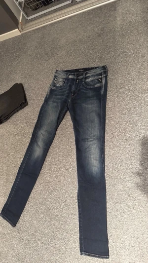 Replay - Snygga blå slim fit jeans från Replay med slitningar och tvättade detaljer. Jeans modellen är Anbass. Storlek är 28/32. Bara höra av dig vid frågor!💬