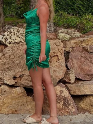 Satinklänning  - Super fin grön miniklänning i satin med tunna axelband och draperad urringning. Klänningen har dragsko i sidan för justerbar längd. Midjan är insydd. För referens: jag är 180cm