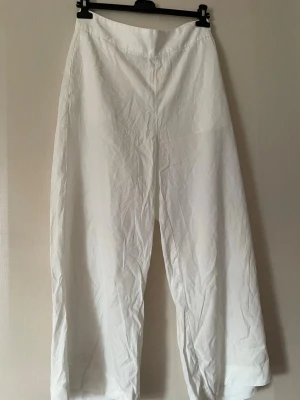Vita vida lindex byxor - Snygga och luftiga vita byxor från Lindex, storlek 42 i mycket bra skick.Vida ben och en avslappnad passform som gör dem både bekväma och stilrena. Hög midja,fickor och dragkedja vid sidan för en smickrande passform. Perfekta till sommaren ☀️