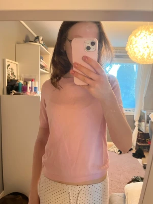 Ljusrosa t-shirt med kort ärm - Söt ljusrosa t-shirt med rund halsringning och korta ärmar. Modellen är rak och enkel, vilket gör den lätt att matcha med olika stilar. Materialet är mjukt och bekvämt ut, perfekt för vardag!