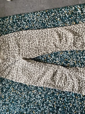 Leopardmönstrade jeans  - Snygga leopardmönstrade jeans från Lindex i grått och vitt. Modellen har klassisk femficksdesign, knappgylf och bootcut . Perfekta för dig som vill sticka ut med ett djurmönster i din outfit. Dom passar till allt möjligt 
