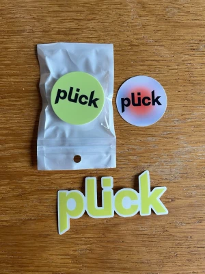Plick PopSocket och klistermärken - Snyggt Plick-kit med en PopSocket i originalförpackning samt två klistermärken. Perfekt för att ge din mobil eller laptop en personlig touch. Alla produkter är i nyskick och har aldrig använts.