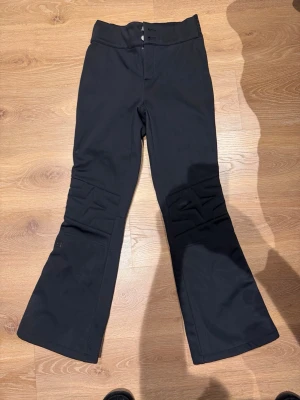 Svarta firgurnära skidbyxor från 8848 i stl.160  med stjärndetaljer - Säljer ett par svarta skidbyxor med snygga diskreta  stjärnmönster på knäna. Nypris ca 1700kr, inköpta på NK . Använda endast 3 skiddagar. 