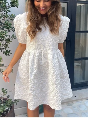 Vit kort klänning med puffärm - Söt vit kortklänning med puffärmar från BY IC. Klänningen är helt oanvänd med prislappen kvar perfekt till studenten💕 Aldrig använd pga beställde flera storlekar!