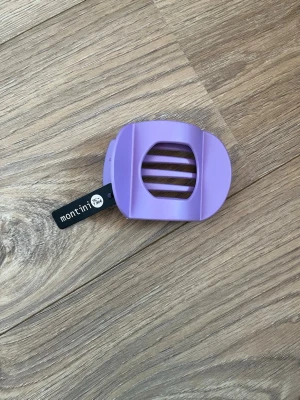 Lila hårklämma från Montini - Snygg lila hårklämma från Montini i plast med breda tänder och modern, rundad form. Matt färg. Helt ny och oanvänd.