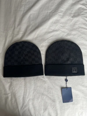 Svart LV Mössa - • Skick: Helt ny och aldrig använd (10/10). • Färg: Svart med det ikoniska mönstret i en diskret ton-i-ton look. • Detaljer: Stilren logga och mjukt, stretchigt material för perfekt passform.