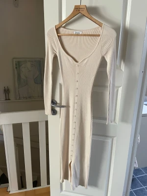 Lång ribbad klänning i beige - Från Chiquelle