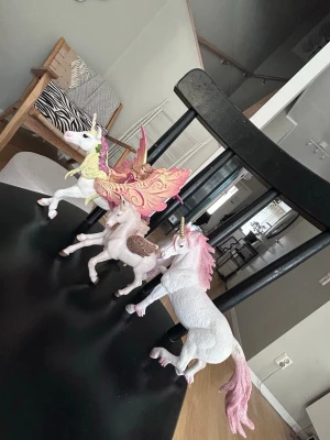 Tre enhörningsfigurer i plast - Säljer tre magiska enhörningsfigurer i plast. En har rosa man och svans, en har stora glittriga vingar i rosa och guld, och den tredje har bruna vingar. Perfekta för dig som älskar fantasy och vill ha något unikt till samlingen.