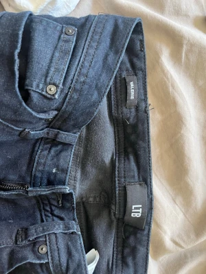 Mörkblå skinny jeans från LTB - Snygga mörkblå skinny jeans från LTB, modell Valerie. Jeansen har klassisk femficksdesign, dragkedja och knapp framtill. Materialet är stretchigt och bekvämt, perfekt för en trendig look. Passar dig som gillar smal passform och stilrena detaljer.