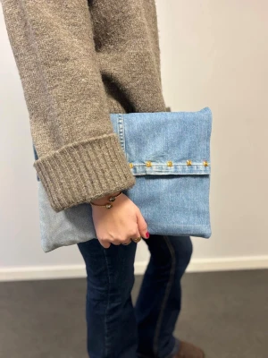 Datorfodral 💙 - Ljusblått datorfodral av återvunna jeans med filt och silke inuti, guldiga nitar och magnetisk knapp!💙 Fodralet är ca 37x27 cm🌟