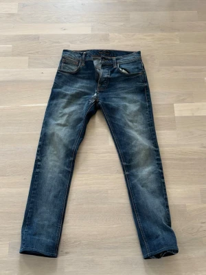 Nudie jeans - Snygga nudie jeans i modellen grim Tim. Finns ett litet hål mellan bena och storlek är 30/30 men är uppsydda. Kontakta mig för bilder på hålet eller hur mycket dom är uppsydda!