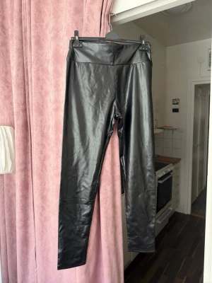 Svarta leggings i skinnimitation – storlek L/XL 5st - Svarta leggings i skinnimitation – storlek L/XL 5st  Snygga svarta leggings i stretchig skinnimitation med hög midja. Bekväma och figurnära modell som passar både till vardag och fest. Mjukt material med bra stretch.  • Färg: svart • Storlek: L / XL • Hög midja • Stretchiga • Skinnimitation (faux leather) • Skick: fint skick  Pris: 120 kr/st Paketpris vid köp av flera 400kr  Kan skickas eller hämtas.