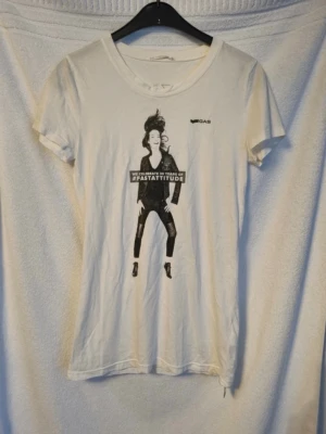Vit t-shirt - Vit lång t-shirt med tryck från GAS. Mycket fint skick max använd 1 gång. Står ingen storlek men uppskattar den till en S. Mått över bysten är ca 42 cm.