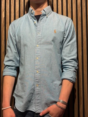 Ljusblå skjorta från Ralph Lauren - Klassisk ljusblå skjorta från Ralph Lauren. Slimfit i storlek M