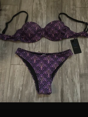 Lila och svart mönstrad bikini - Snygg bikini som jag köpte i Thailand! Överdelen har push up. Storleken är 40 men är som xs/s💓Säljer en likadan i turkos!