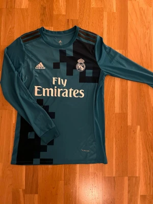 Ronaldo matchtröja  - En Real Madrid matchtröja med Ronaldo på ryggen. En av de mest legendariska upplagorna av laget och fin tröja med med blå och mörkblå. Lite större i storleken.