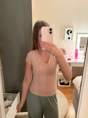 Ljusrosa t-shirt med v-ringning - Säljer en ljusrosa t-shirt med v-ringad hals och korta ärmar. Modellen är figurnära och enkel, perfekt för en clean och stilren look. Materialet är stretchigt. Säljer p.g.a. För liten. Priset kan diskuteras ❣️