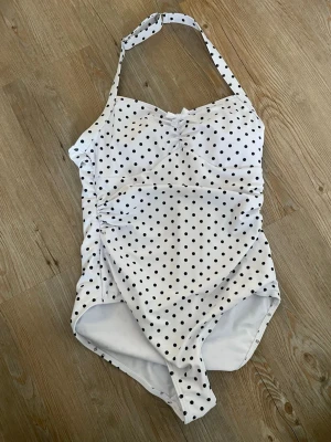 Vit baddräkt med svarta prickar - Säljer en söt vit baddräkt eller body vet inte riktigt vad det är men är i baddräkt material. Köpt på Vinted.