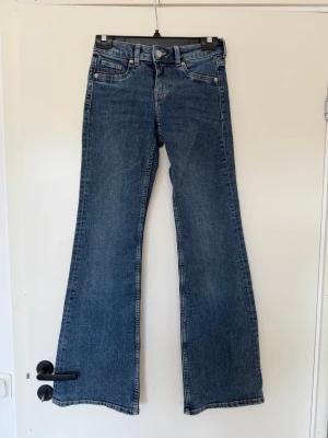 Blåa low waist jeans - Ett par blåa low waist jeans från Hm. Använda ett fåtal gånger.