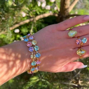 Armband med dubbla rader kristaller Rainbow  - Armband i guldpläterad mässing. Egen design. Två rader med kristaller. Light Sapphire, Jonquil, Light Rose, Chrysolite och Violett. Ss39, 8mm stora kristaller. Längd 24cm inkl lås och förlängningskedja.   Jag skickar endast spårbart, samfraktar. Fast pris. Besök gärna mina övriga annonser.  Till mina smycken använder jag kristaller från Preciosa, Aurora och Swarowski.