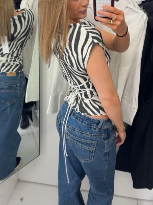 Extra low waist, straight blue jeans from Gina - Säljer en slim zebramönstrad topp i svart och vitt med korta ärmar och snygg snörning i ryggen. Toppen har croppad passform och markerar midjan på ett riktigt snyggt sätt. Perfekt för dig som vill sticka ut lite extra. Jag har ej använt de sätskillt mycket eftersom jag inte känner mig bekväm i dem.