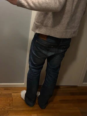 Lee jeans straight/relaxed fit - Säljer ett par blå jeans med klassisk passform och snygga detaljer på bakfickorna. Jeansen har fem fickor och en läderpatch bak i midjan. Materialet är slitstarkt denim och färgen är mörkblå med lätt tvättade partier. Storlek: W32 L32. Jeansen är lagade vid skrevet något som dock inte syns när man har på sig dem.😃 Fråga gärna om du har funderingar🤍