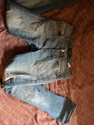 Blå slim fit jeans från replay - Snygga blå slim fit jeans från River Island med klassisk femficksdesign och dragkedjegylf. Jeansen har en lätt tvättad look och är tillverkade i bomullsdenim med lite stretch för extra komfort.