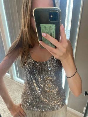 Glittrig silver paljettopp - Snygg glittrig topp i silver med paljetter över hela plagget. Linnemodell med smala axelband och rundad halsringning. Perfekt festtopp som passar till både jeans och kjol! Den glimmrar så fint i ljuset och kliar inte som andra paljetttopoar kan göra ofta💓🤗
