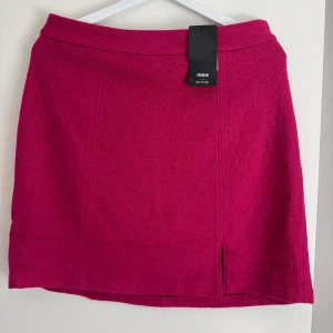 New Orsay fuchsiafärgad mini kjol, storlek 38 - New mini Kort kjol i en livlig fuchsiafärg med en diskret slits framtill. Kjolen har en dragkedja baktill för enkel på- och avtagning. Den är designad med en rak passform som slutar ovanför knät, vilket ger en modern och stilren look. Perfekt för att lägga till en färgklick i garderoben. Length: 49 cm  Buy shipping label or pick it up from Farsta centrum in Stockholm.