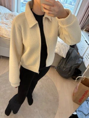 Krämvit teddyjacka med dragkedja - Använd få gånger, i fint skick. Står strl M på den, men passar mig som har strl Xs och passar nog även någon med strl S.