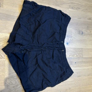 Mörk blåa shorts från H&M - Säljer ett par blåa shorts från H&M i storlek M. De är i bra skick och har en bekväm elastisk midja med snörning. Perfekta för sommarens varma dagar eller en avslappnad dag hemma. Materialet känns mjukt och skönt mot huden. Säljer då dom är förstora för mig🩷