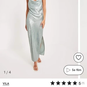 Silvrig långklänning från Vila - Säljer en silvrig långklänning från Vila. Klänningen har en glittrig finish och en öppen rygg med knytband. Den är ärmlös och har en slits på sidan för extra stil. Perfekt för nu till nyår eller till bal✨✨ klänningen är helt nu och endast testad så skicket är som nytt 