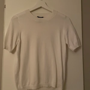 Vit kortärmad tröja från Lindex - Säljer en stilren vit tröja från Lindex i storlek XS. Den är kortärmad och har en rund halsringning. Perfekt för både vardag och festliga tillfällen. Tröjan är i bra skick och gjord av mjukt material som känns skönt mot huden.