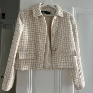 Beige rutig kavaj från Zara - Säljer en superfin beige rutig kavaj från Zara i mycket bra skick. Perfekt för höst och vår, och funkar både till vardags och fest. Storlek M, men passar även som en S