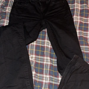 Svarta bootcut jeans från True Religion - Säljer ett par svarta bootcut jeans från True Religion i storlek 25. De är midwaist och har snygga detaljer med knappar på bakfickorna. Det är använda en gång 