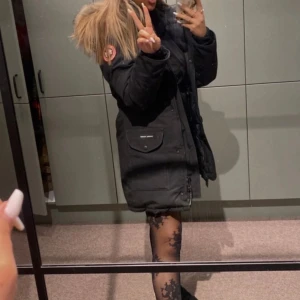 Svart parkajacka med pälsdetaljer - Säljer en svart canadajacka. Perfekt för kalla vinterdagar. Den är i bra skick med några små defekter på innerfodret på ärmarna men syns inte då det är på insidan. Jackan är äkta men jag har inte kvar kvitto därför säljes den billigt. 😊