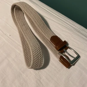 Beige flätat bälte med silverdetaljer - Säljer ett snyggt beige flätat bälte som kostade 200 kr nypris som jag nu säljer  för 99kr 