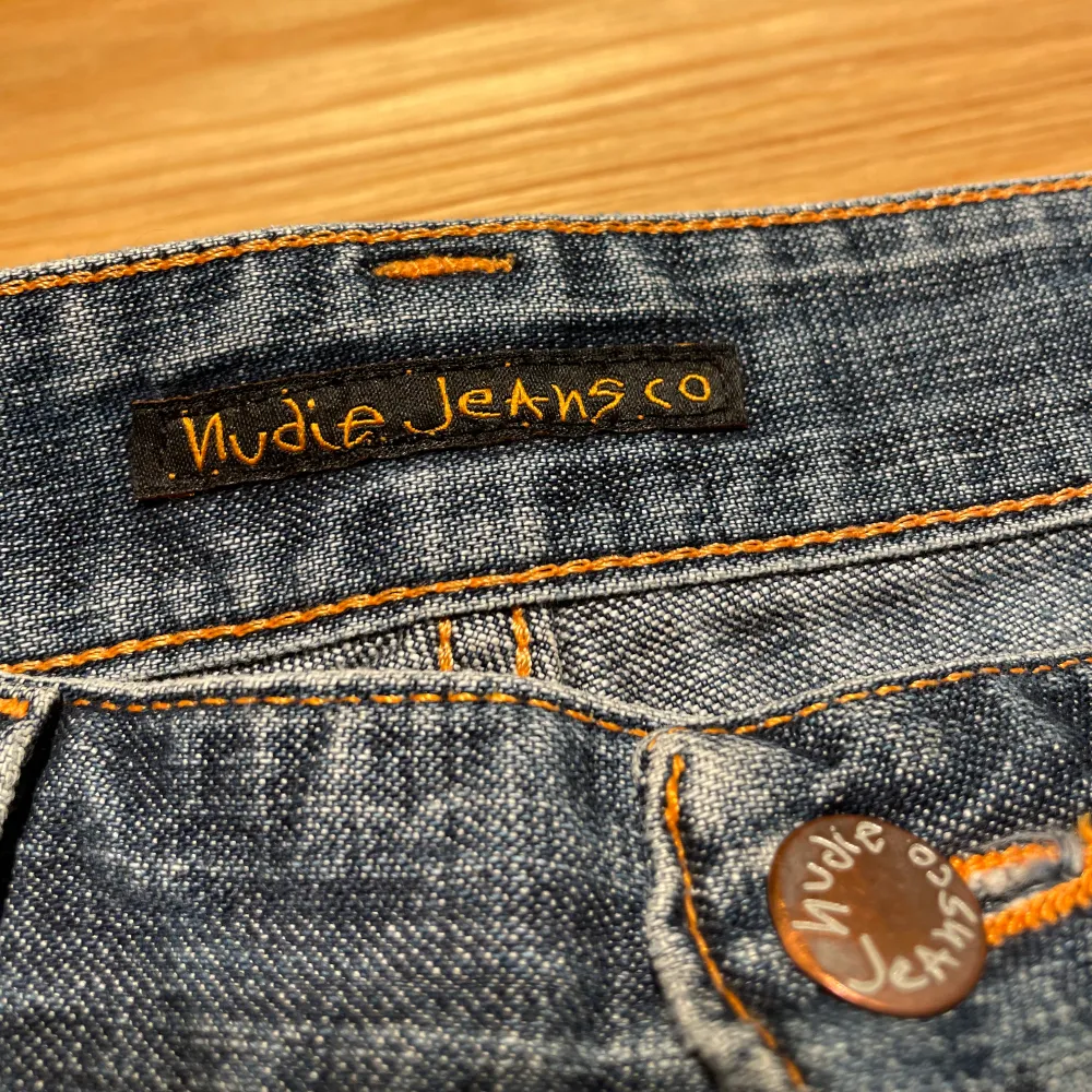 Säljer ett par klassiska blå jeans från Nudie Jeans i storlek W32 L34 bootcut Ola. De har en snygg passform och är i bra skick. Perfekta för vardagsbruk med en tidlös stil. Jeansens material är slitstarkt och bekvämt, vilket gör dem till ett måste i garderoben.. Jeans & Byxor.