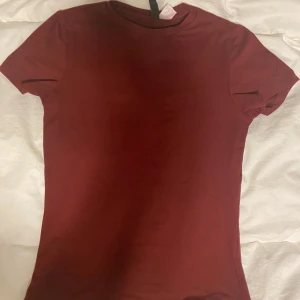 Formfitting skimsdupe t-shirt - Jättefin vinröd färg som är tight och ltyo skimsdupe. Endast använd en gång så i princip helt ny.