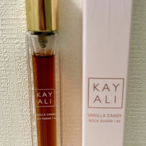 Vanilla Candy Rock Sugar Eau de Parfum 10 ml by Kayali - En vacker len, rik, söt, fruktig, djup, flörtig vaniljparfym från Kayali. Enligt mig en perfekt mix av La Belle by Jean Paul Gaultier och Vanilla 28 by Kayali. 10 ml, endast testsprayad. Givetvis förvarad mörkt och svalt. Kommer i originalförpackningen. 