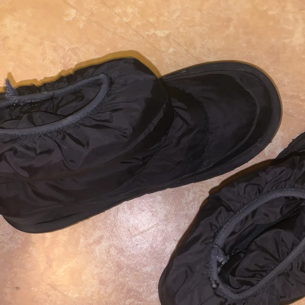 Säljer ett par svarta uggs i syntetmaterial. De är varma och perfekta för kalla dagar. Stövlarna har en robust sula och en tight passform som håller fötterna torra och bekväma. Perfekta för vinterns alla äventyr! Använda ett antal gånger men annars i nyskick . Kengät.